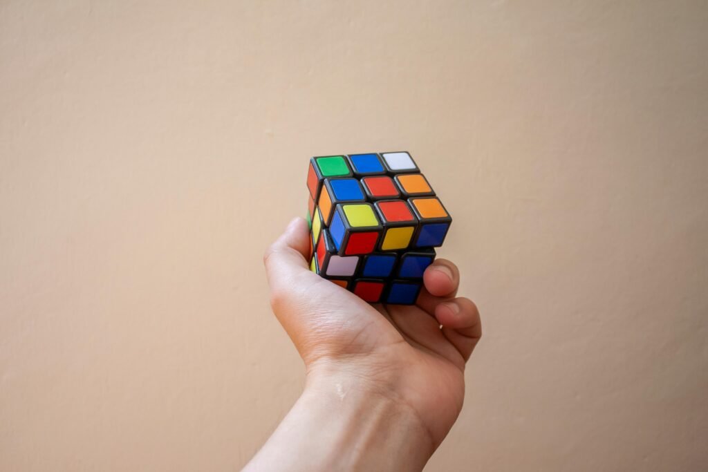 Close-up of a hand holding a colorful Rubik